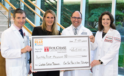 Maria Grasso, executive director of Get Your Rear in Gear Philadelphia, presented the check to Joshua Meyer, MD, attending physician of radiation oncology (left); Dr. Farma; and Crystal Denlinger, MD, assistant professor of medical oncology.